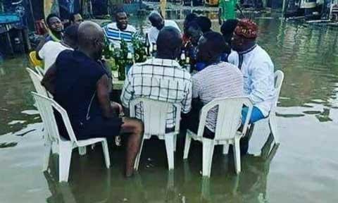 Photo Of The Day: Men Drinking Beer In Lagos Flood